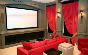 interior-home-theater-living-room-ideas-interior-decorator-set-with-soft-gray-wall-and-red-curtain-also-unique-wall-lights-plus-widescreen-and-cozy-red-sofa-appealing-for-home-entertainment-design-ide